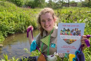 Claudia Martin holding an act on climate change poster and hand made bunting