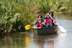 Family paddling on canoe safari at Slimbridge