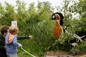 A pair of young boys looking at the Lego red-breasted goose model.