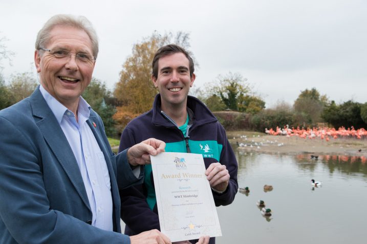 WWT CEO Martin Spray presents PhD researcher Paul Rose with the BIAZA gold certificate.