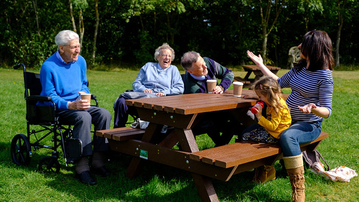 family on picnic benches