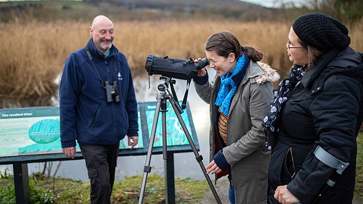 A group birdwatching through a telescope