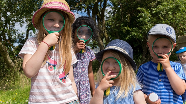 Children with magnifying glasses in nature