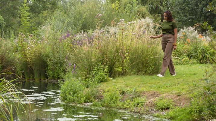 A young woman walking in a lush green wetland in summer