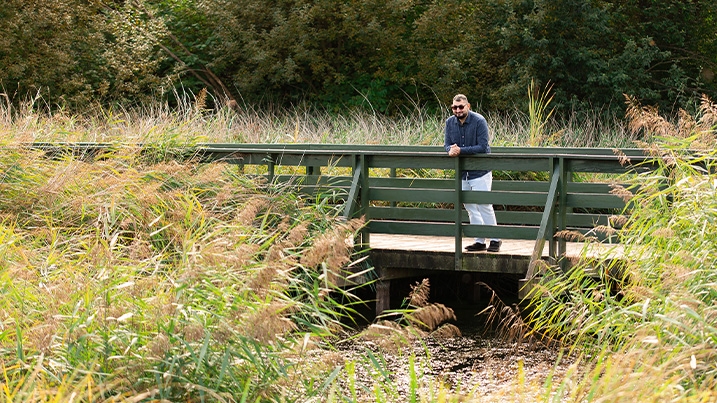 Harune standing on a boardwalk bridge, looking over the water