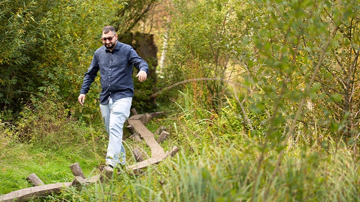 Harune walking along a wooden balance beam that's part of the Wild Walk at London Wetland Centre