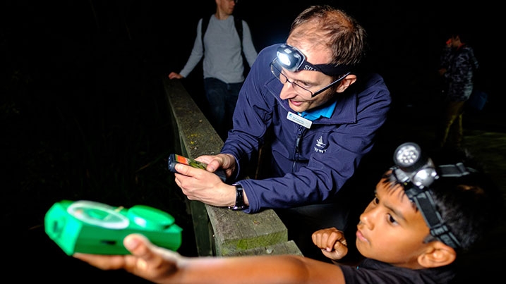 A child with a member of staff participating in a bat walk