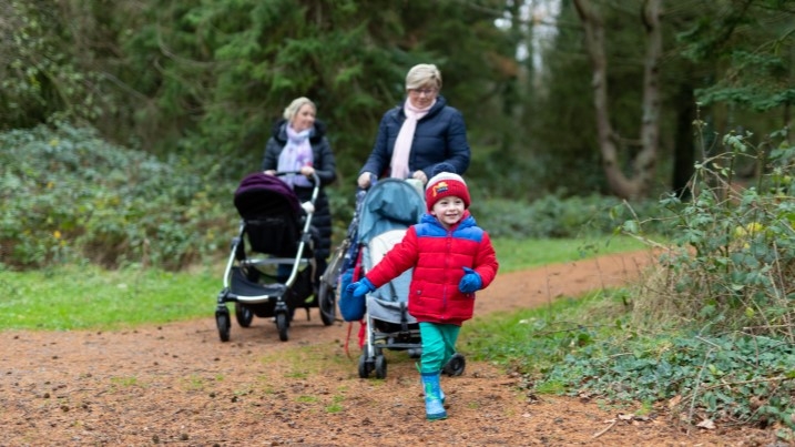 Family walking through woodland in winter clothing