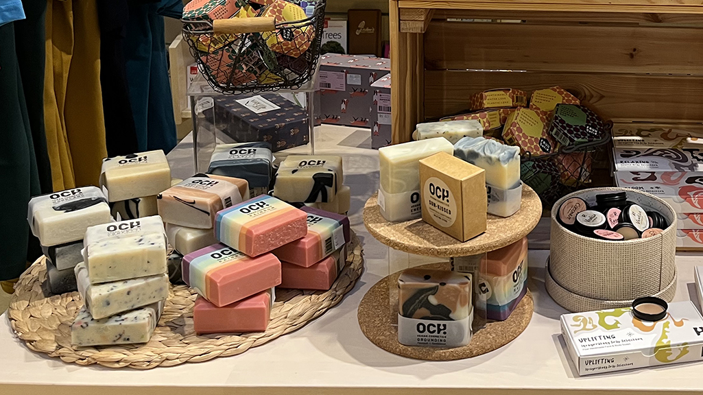 Soaps and cosmetics are displayed on a wooden table.