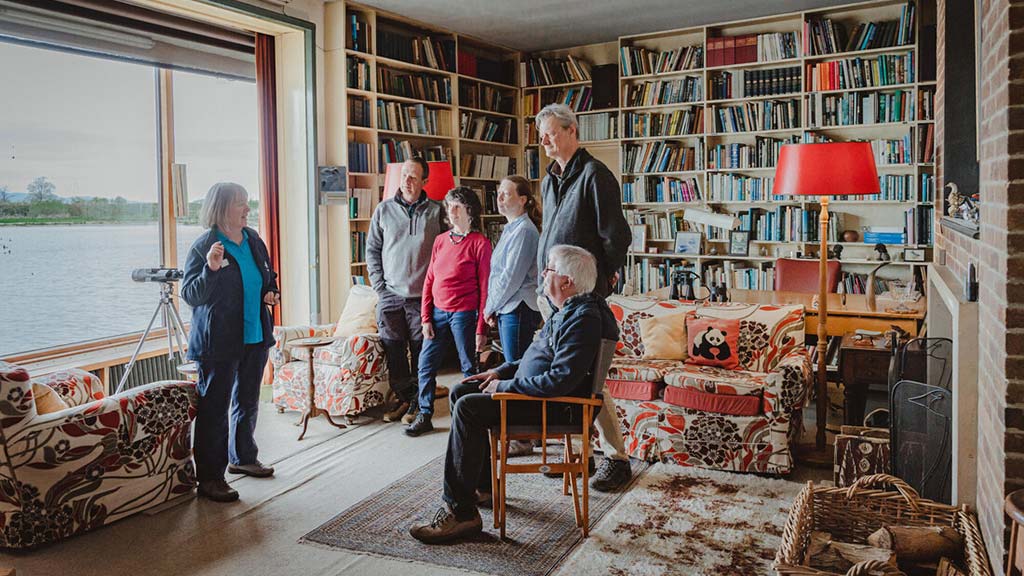 Visitors in Scott House living room, enjoying a tour with a WWT volunteer.