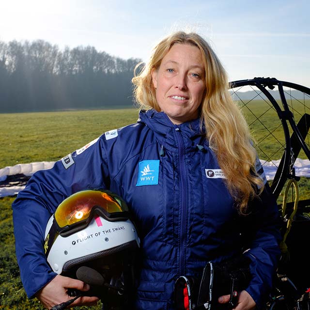 Sacha Dench stands in fron of a paramotor with a helmet under one arm