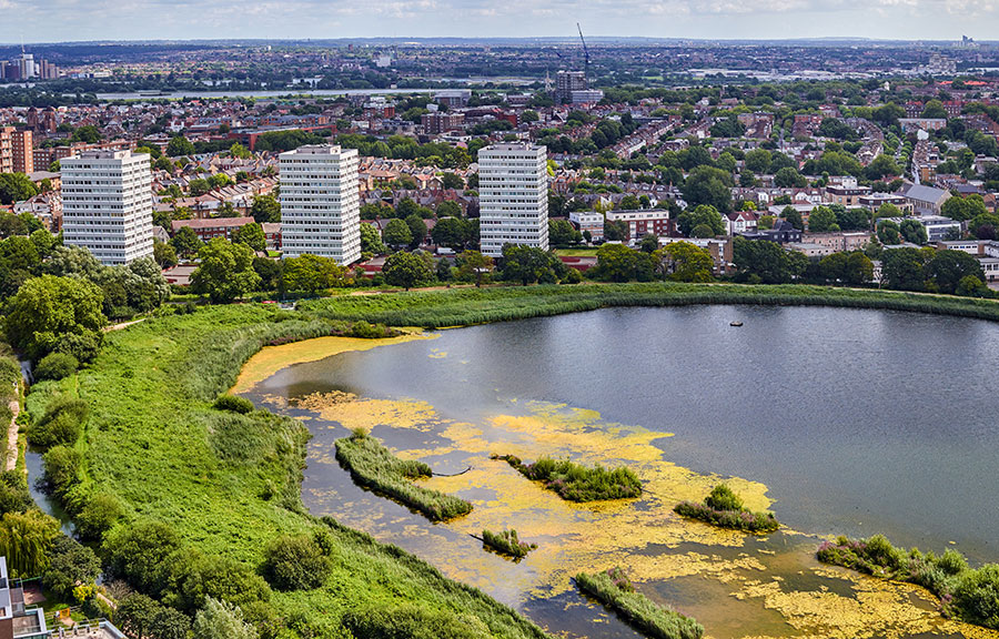 An aerial view of a lake surrounded by a city and high-rise buildings
