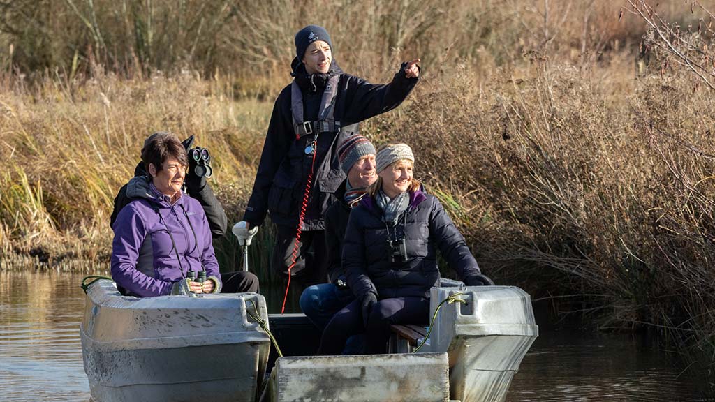 A family enjoying a boat safari at WWT Martin Mere in winter