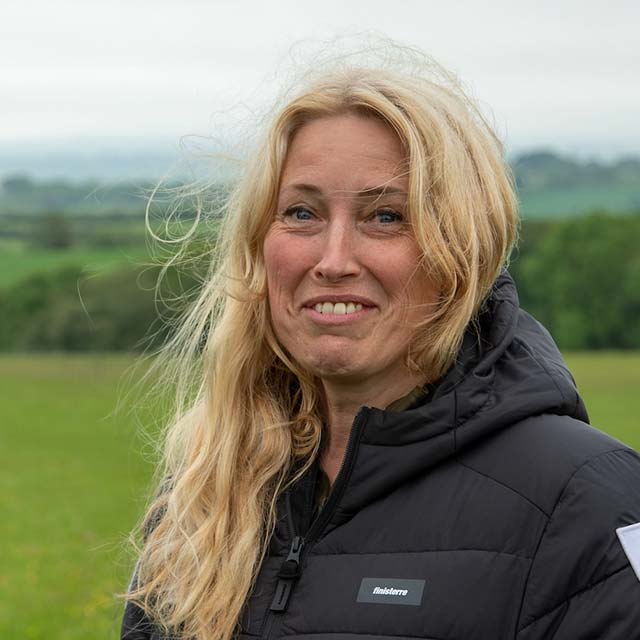Sacha Dench stands in fron of a paramotor with a helmet under one arm
